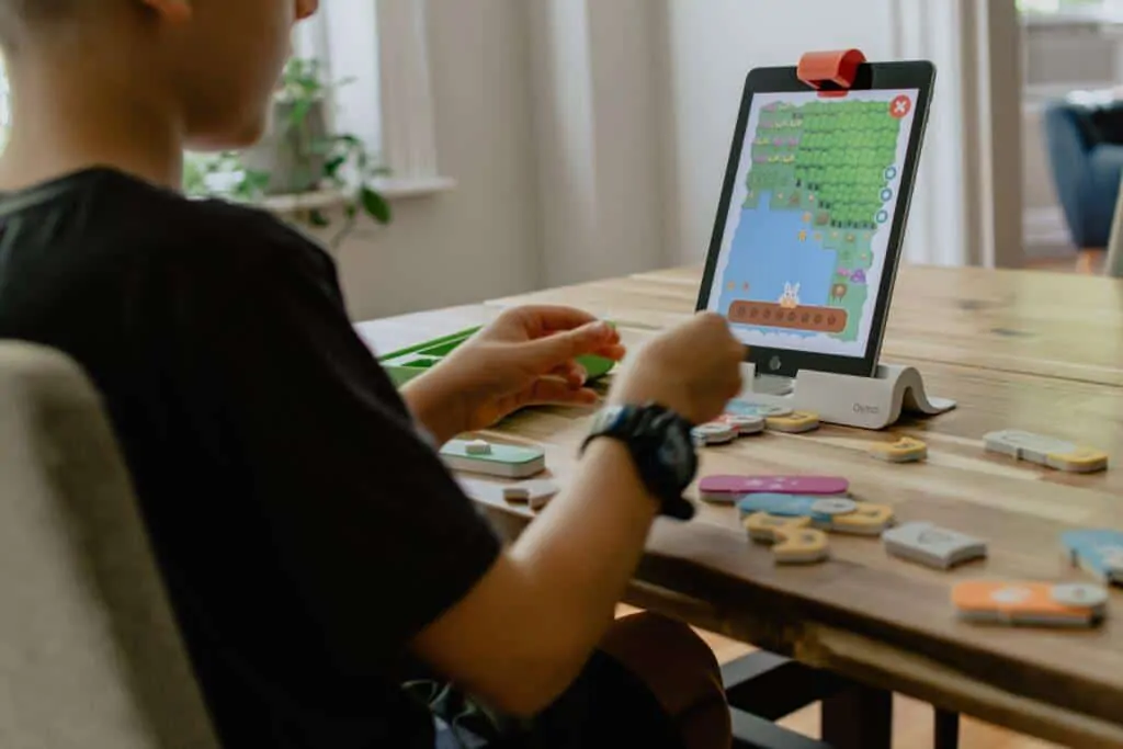 Kid playing Osmo Coding Awbie on an iPad
